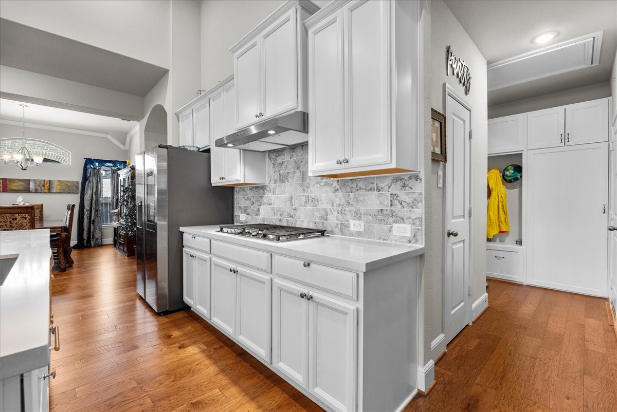 Chef's eat-in island kitchen features 42" cabinets with crown molding, quartz countertops, and stainless steel appliances