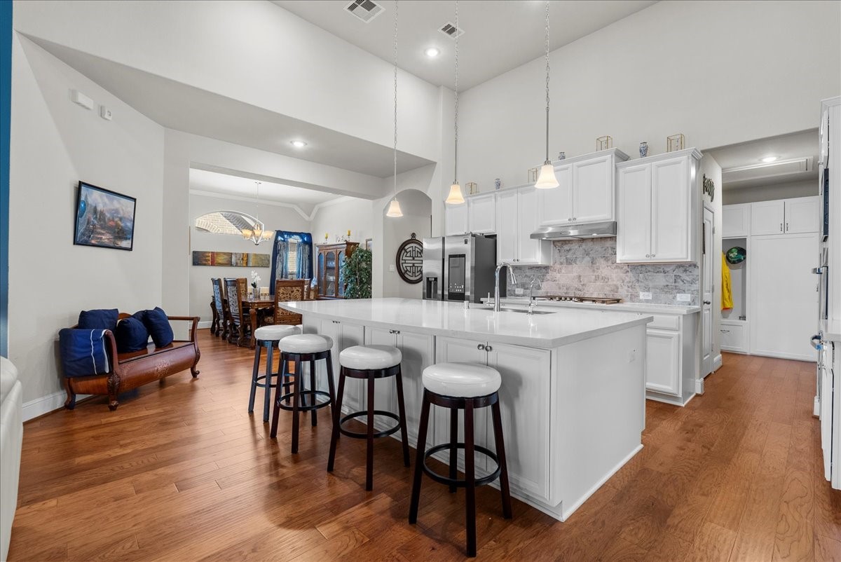 Chef's eat-in island kitchen features 42" cabinets with crown molding, quartz countertops, and stainless steel appliances