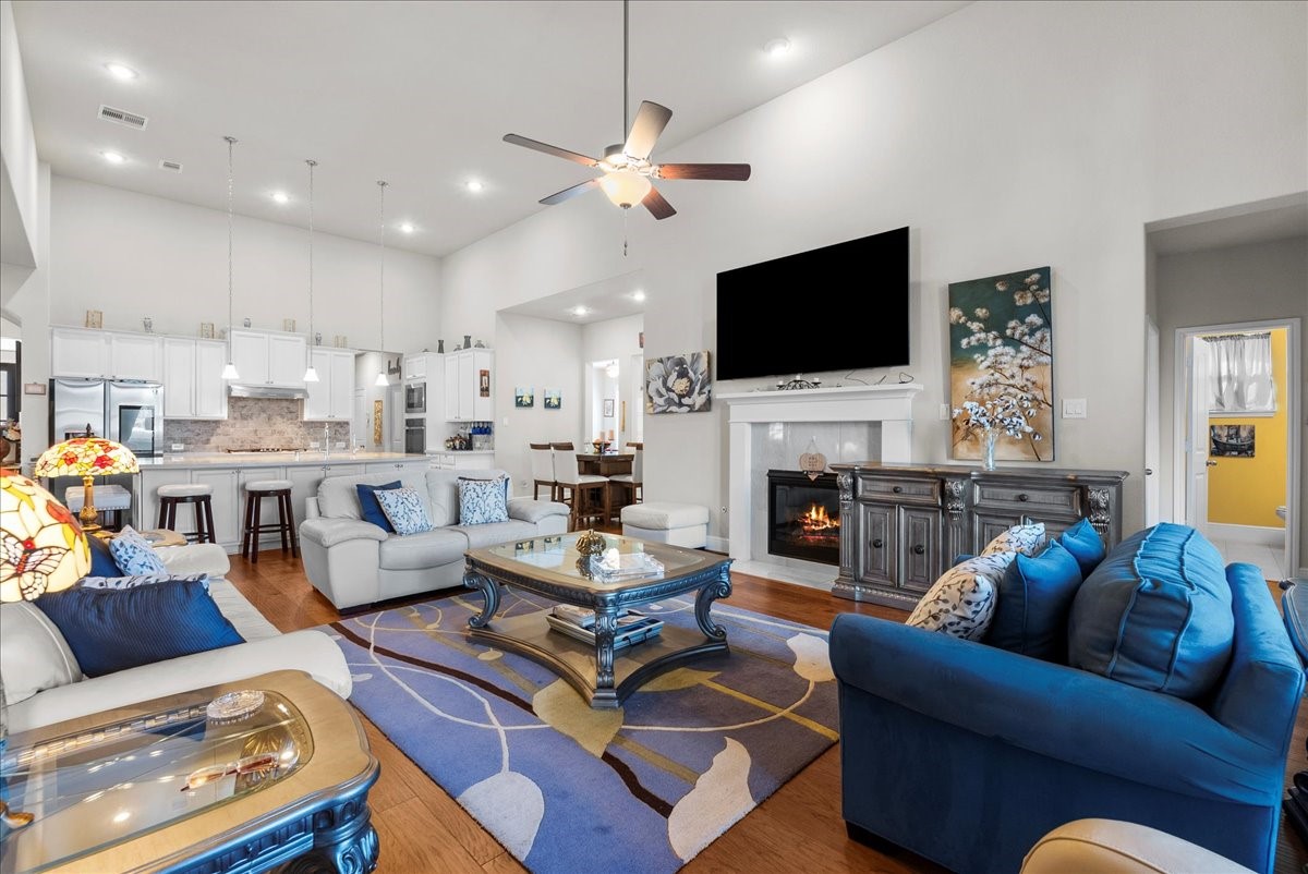 The living room features a cozy fireplace, high ceilings and a wall of windows