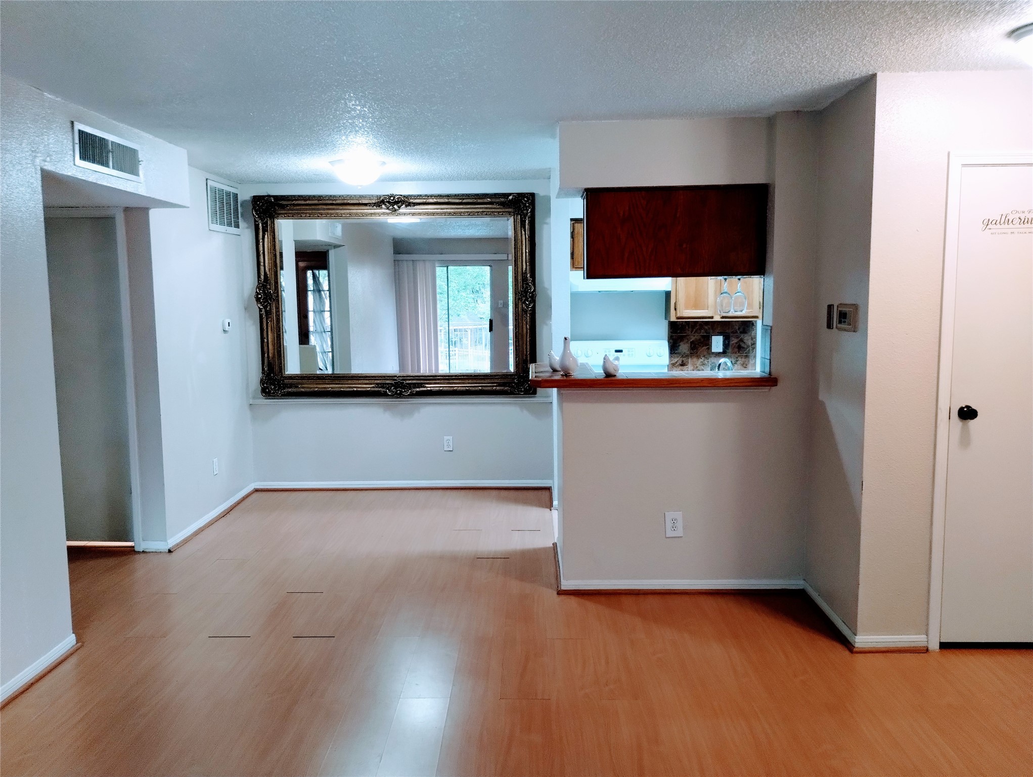 The DINING ROOM is open to the Kitchen and adjoins the Living Room.  There is a coat closet in the Foyer on the right and the Bathroom is conveniently located through the opening on the left.  The gorgeous mirror in the Dining Area stays and magnifies the size of the living area.