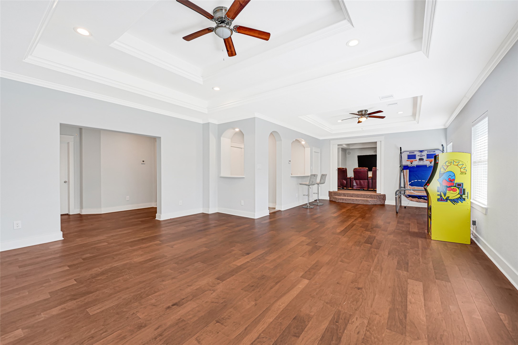 Another view of the spacious upstairs game room highlights wood flooring and plenty of space for games and seating.