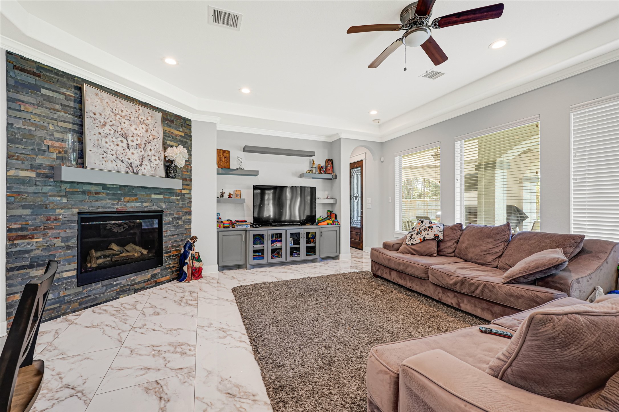 Spacious family room features a fireplace and windows overlooking the backyard.