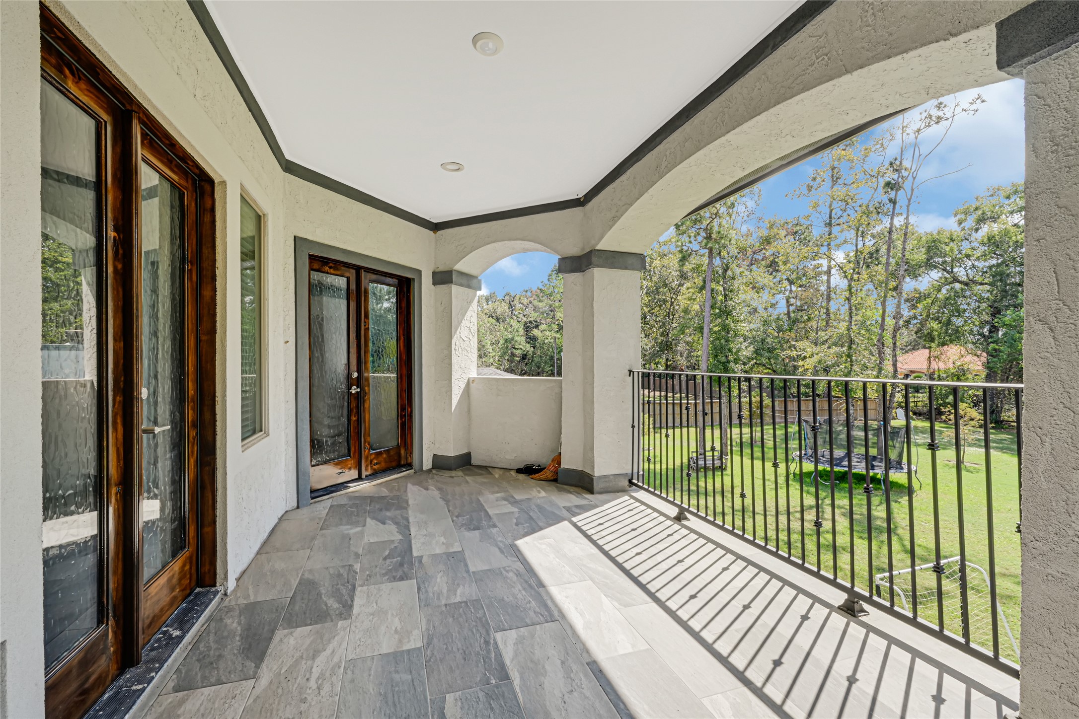 Covered upstairs balcony overlooks the spacious backyard and surrounding trees.