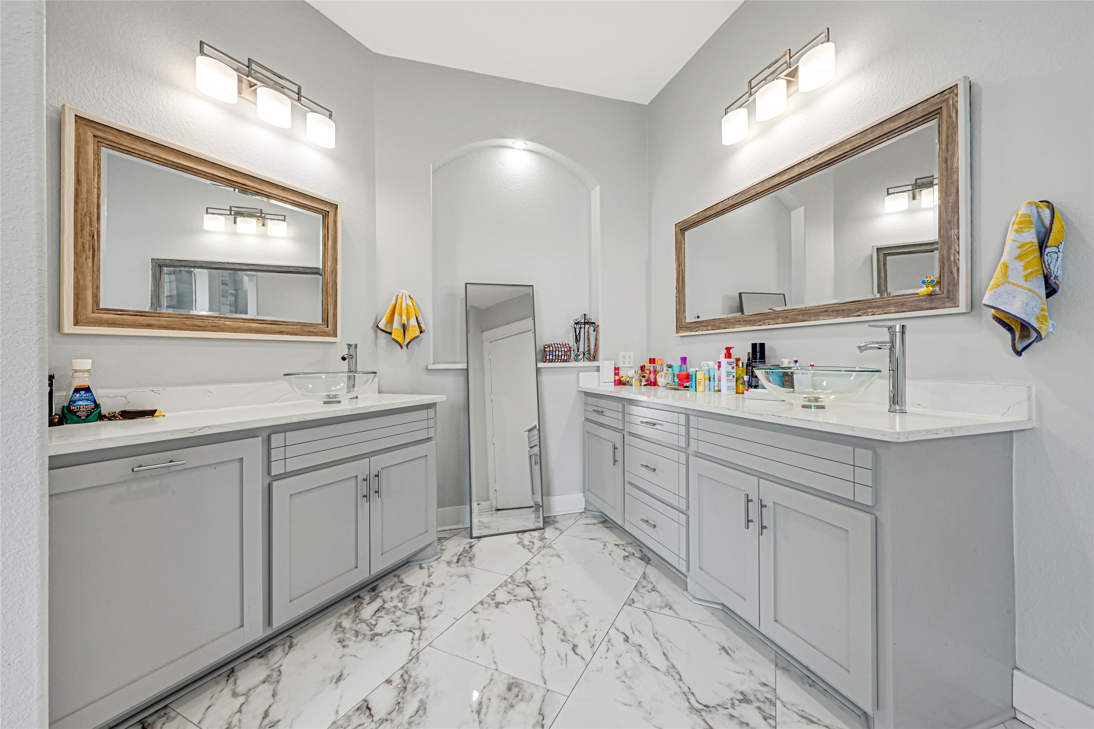 Separate vanities offer ample counter space and storage in this spacious bathroom.