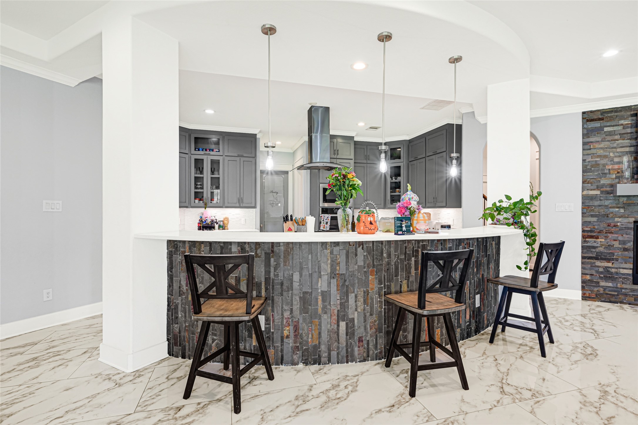 Curved breakfast bar offers casual seating and a convenient gathering spot beside the kitchen.