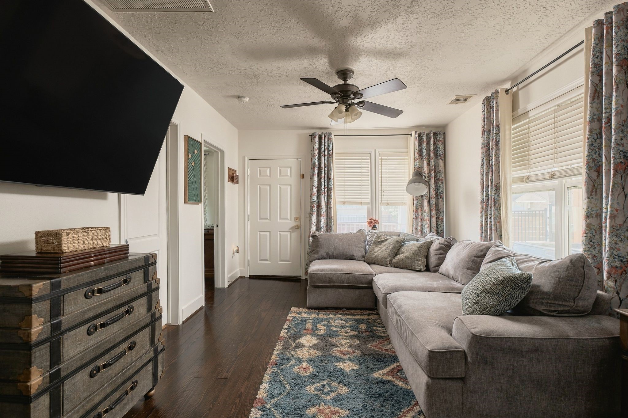 Welcoming living room with original hardwood flooring and an inviting front entry. This thoughtfully renovated Brooke Smith bungalow combines classic 1925 character with the conveniences of modern living.