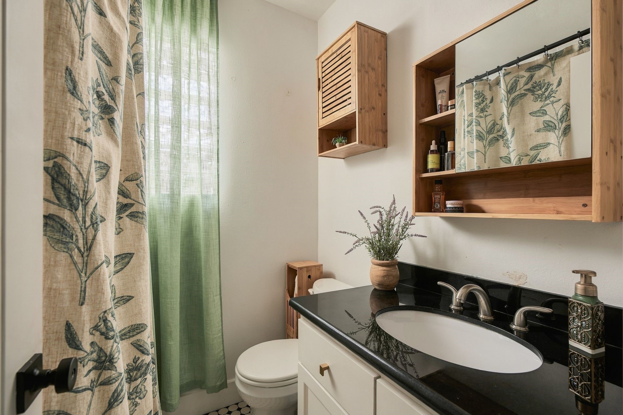 Private primary bathroom with vanity storage and a tub-shower combination. Enjoy the convenience of two full bathrooms in this thoughtfully renovated 1925 Houston bungalow.