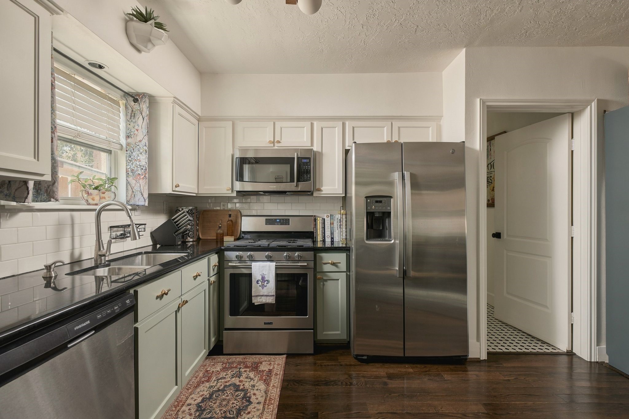 Updated kitchen featuring stainless steel appliances and an open layout overlooking the main living areas. Enjoy the convenience of modern amenities within a classic Houston bungalow.