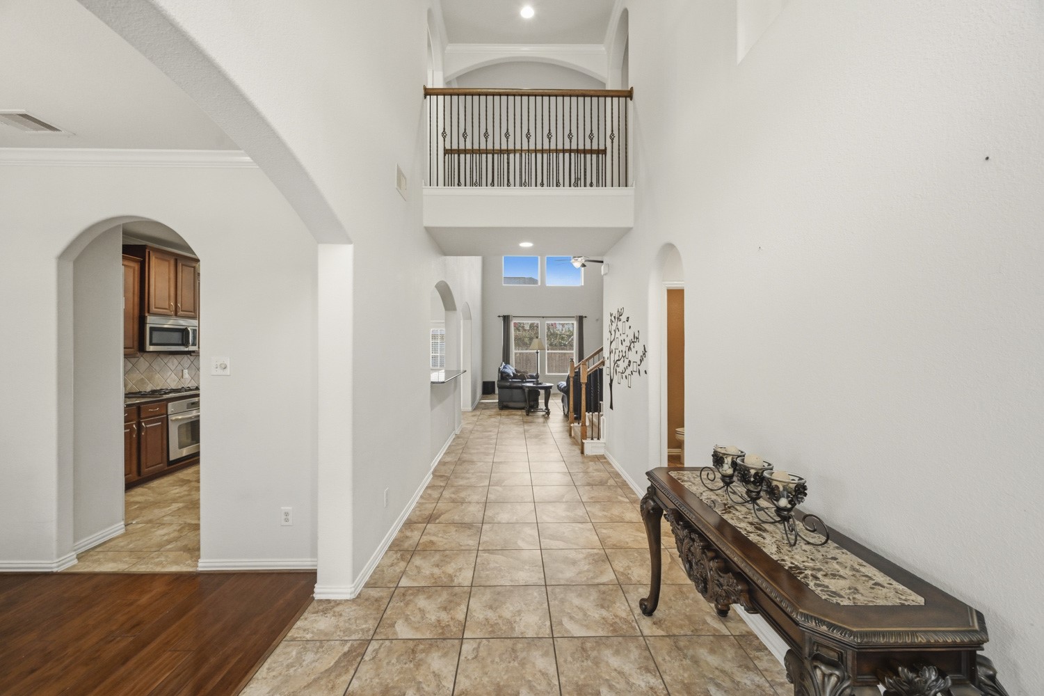 Step inside this inviting entrance, where towering ceilings and sweeping architectural arches create an immediate sense of warmth and space.
