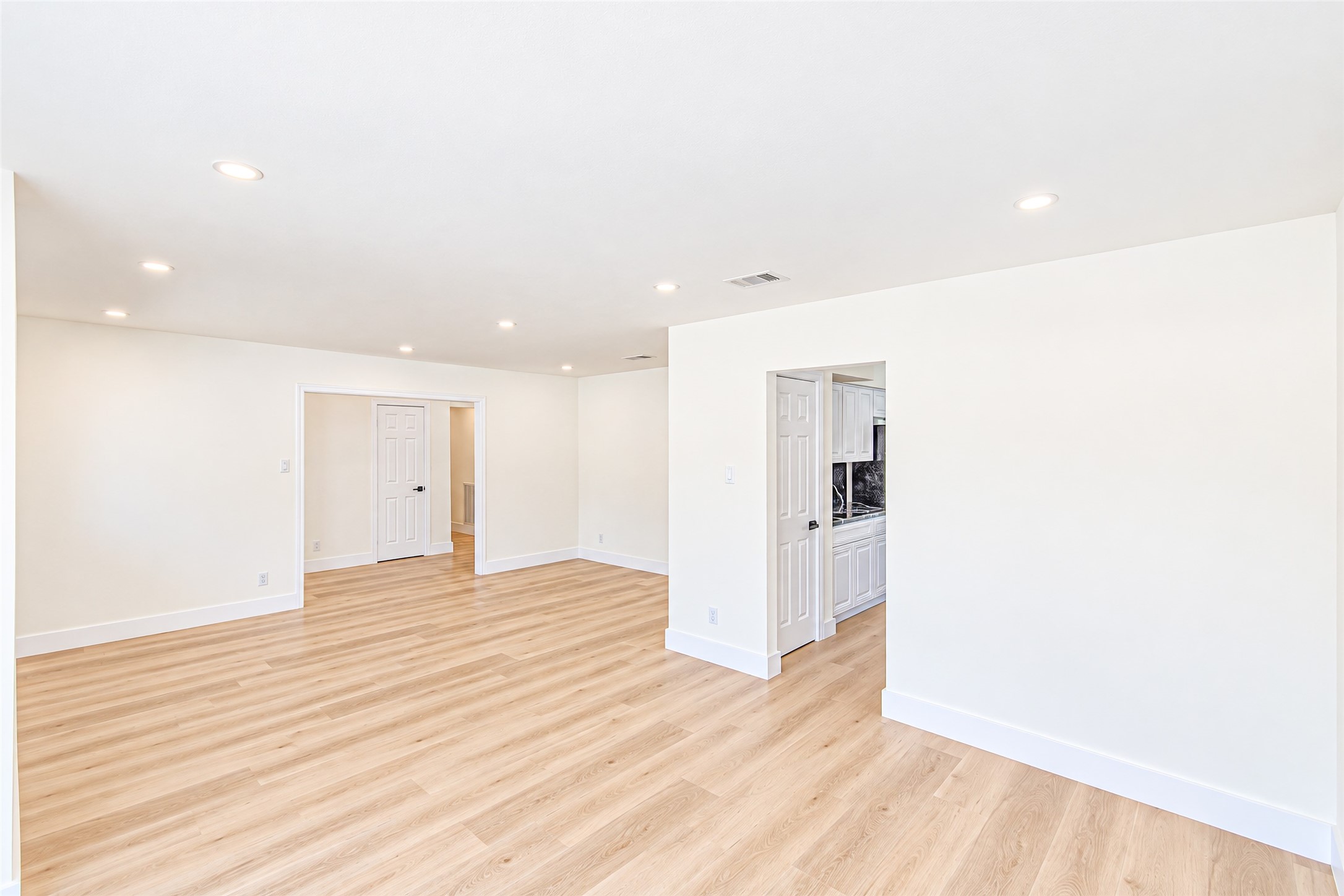 Bright and inviting, this spacious dining room boasts sleek hardwood floors and seamless kitchen access, ideal for entertaining and everyday gatherings.