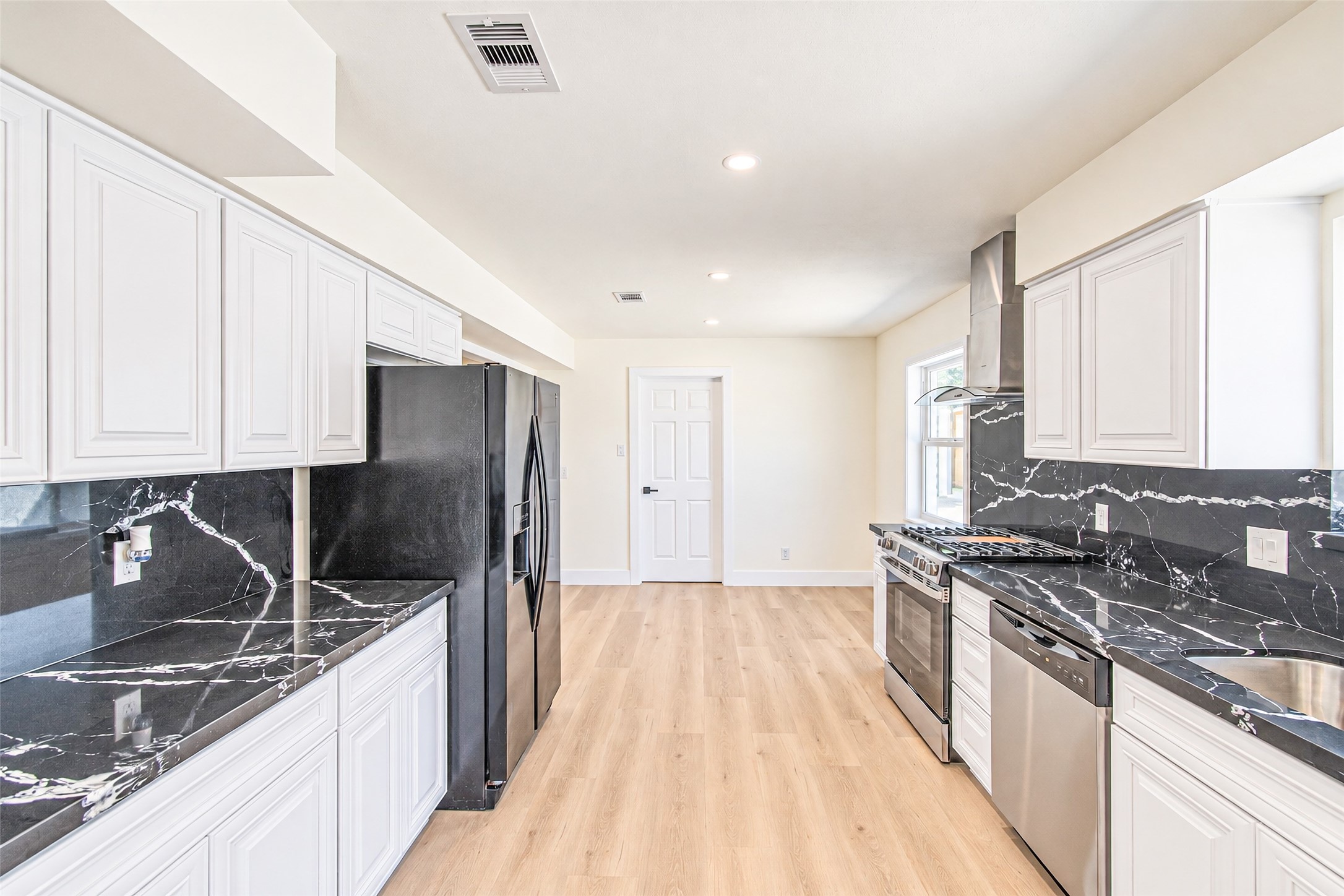 Discover modern elegance in this bright, open kitchen featuring sleek quartz countertops and backsplash.