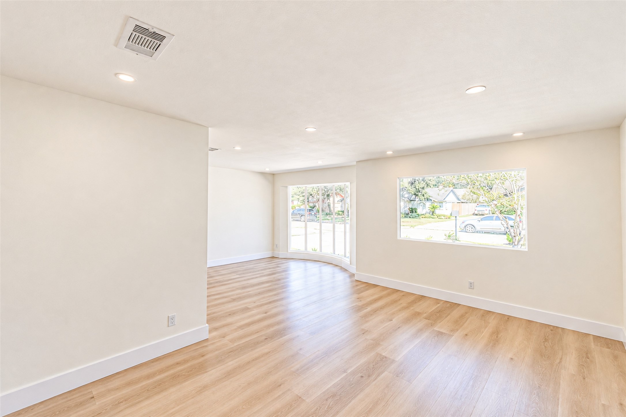 The bright and inviting dining room, with expansive windows and elegant wood flooring, offers the perfect setting for memorable gatherings.