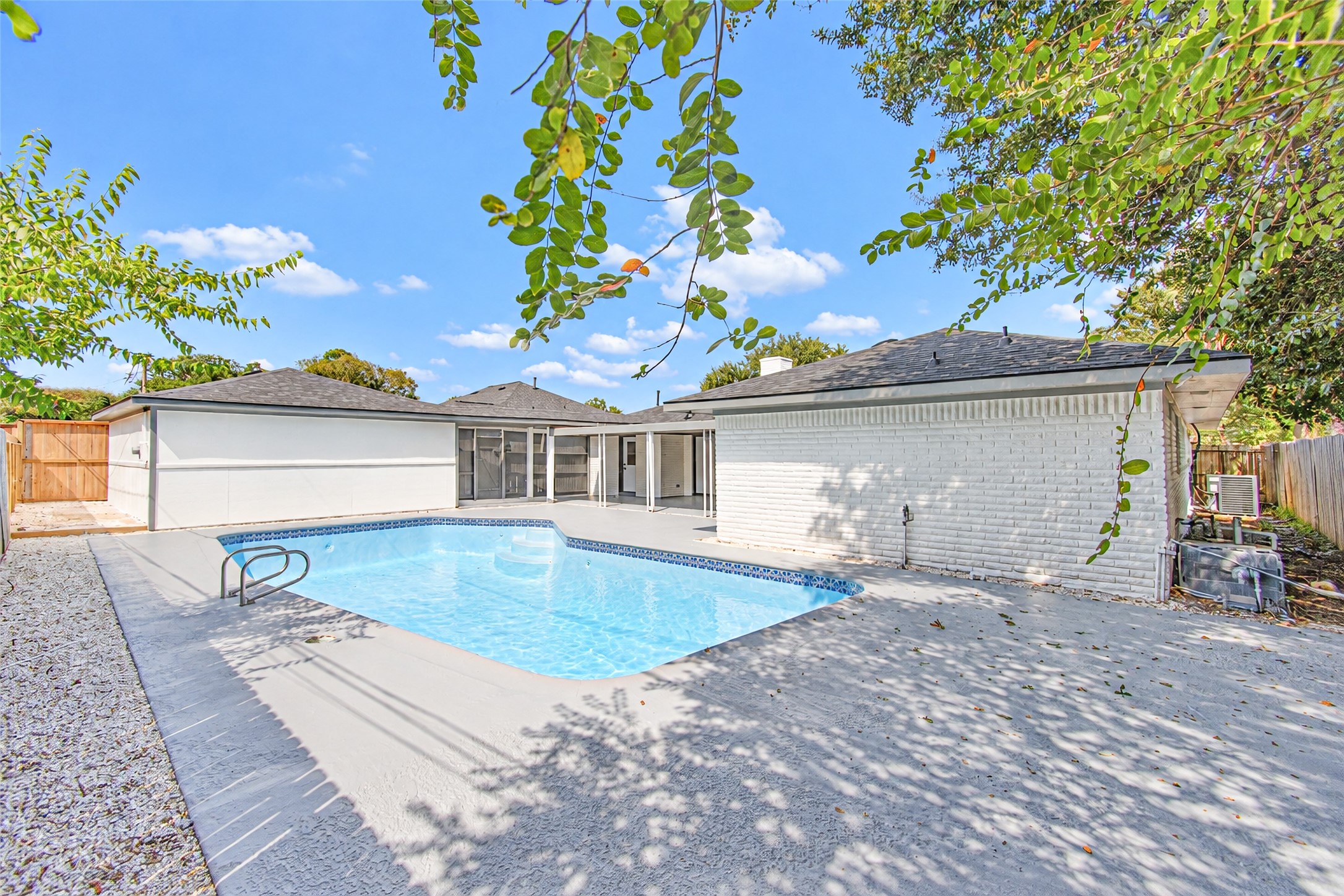 Charming backyard oasis featuring a sparkling swimming pool and spacious patio, perfect for outdoor entertaining and relaxation.
