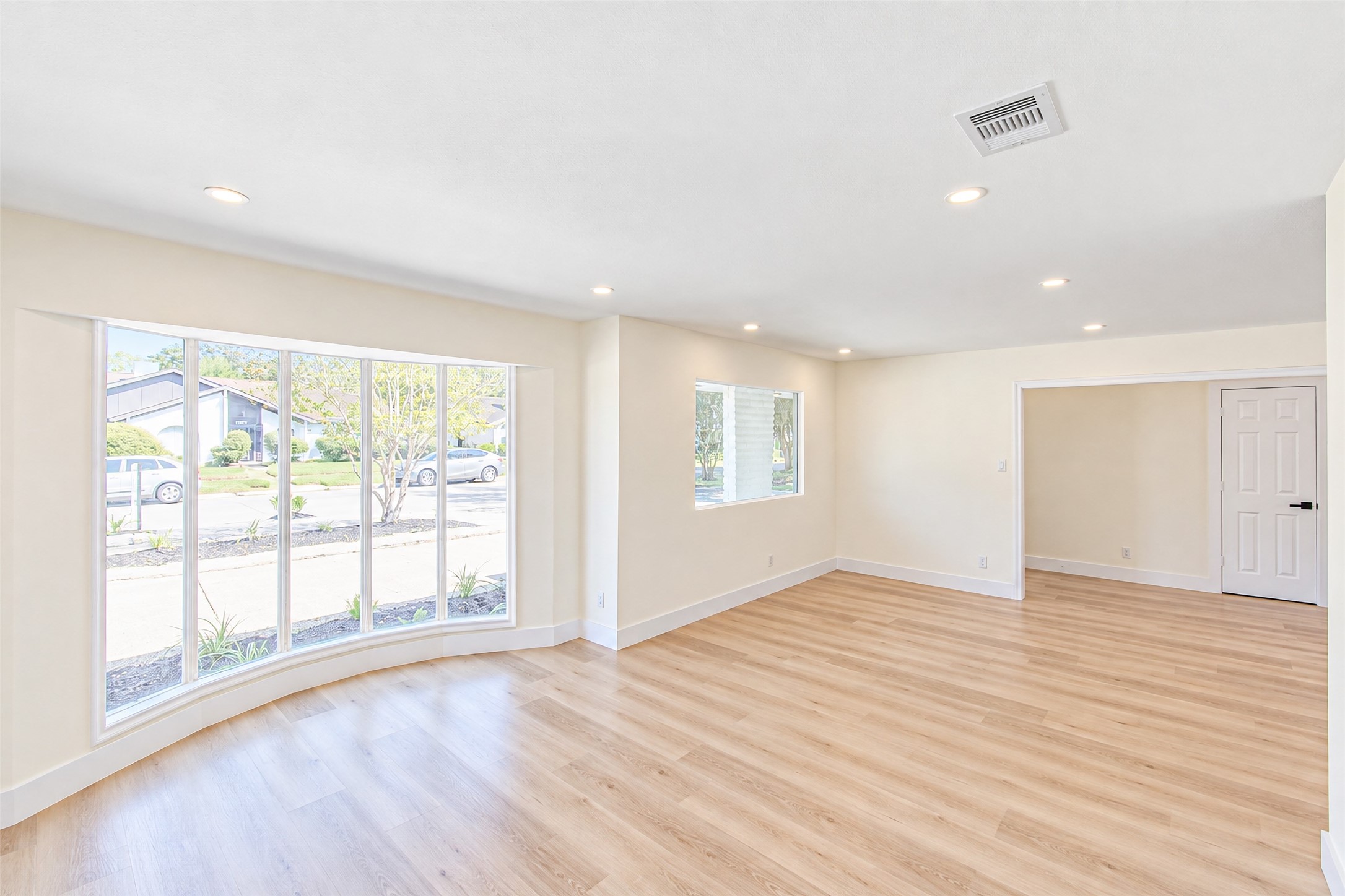 Flooded with natural light through expansive windows, this bright and inviting dining room is perfect for gatherings.