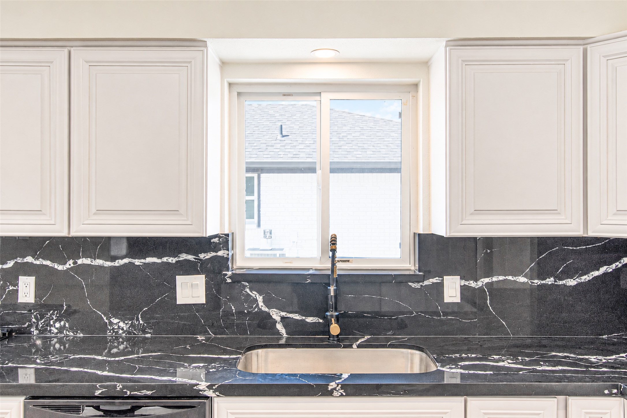 Sleek and modern, this kitchen boasts elegant quartz countertops and a matching backsplash, ideal for culinary enthusiasts.