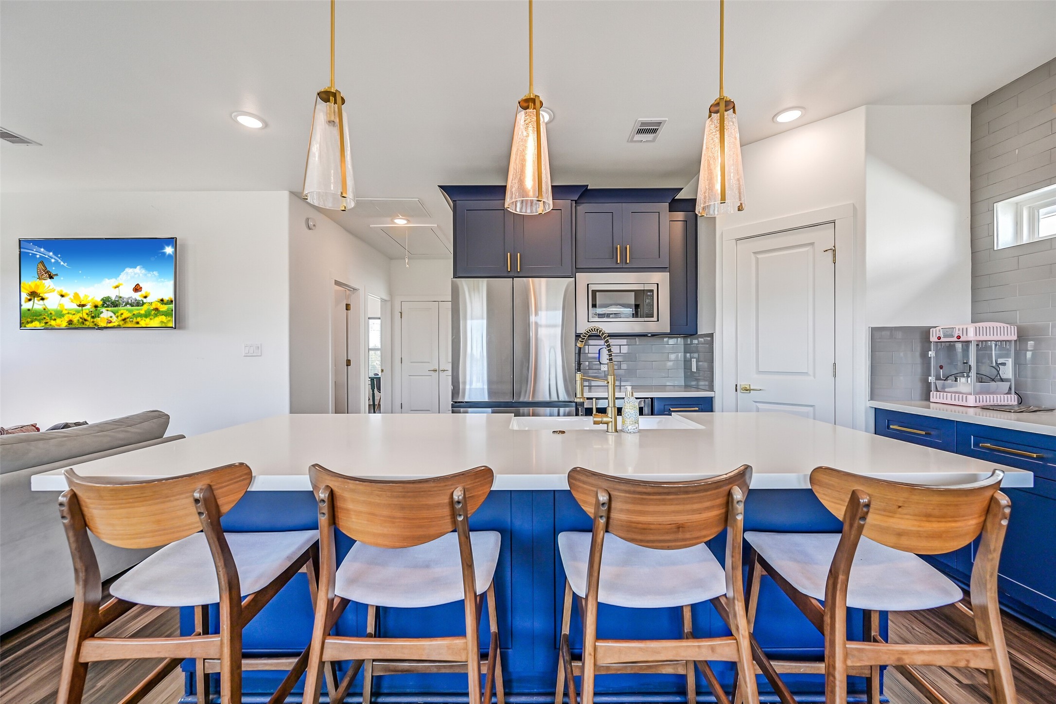 The kitchen features a spacious breakfast bar with quartz countertops and seating for four.