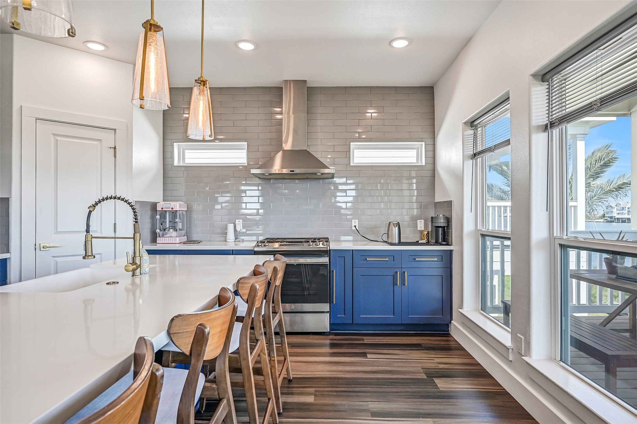 The kitchen showcases beautiful quartz countertops, elegant gold accents, and blue soft-close cabinetry throughout.