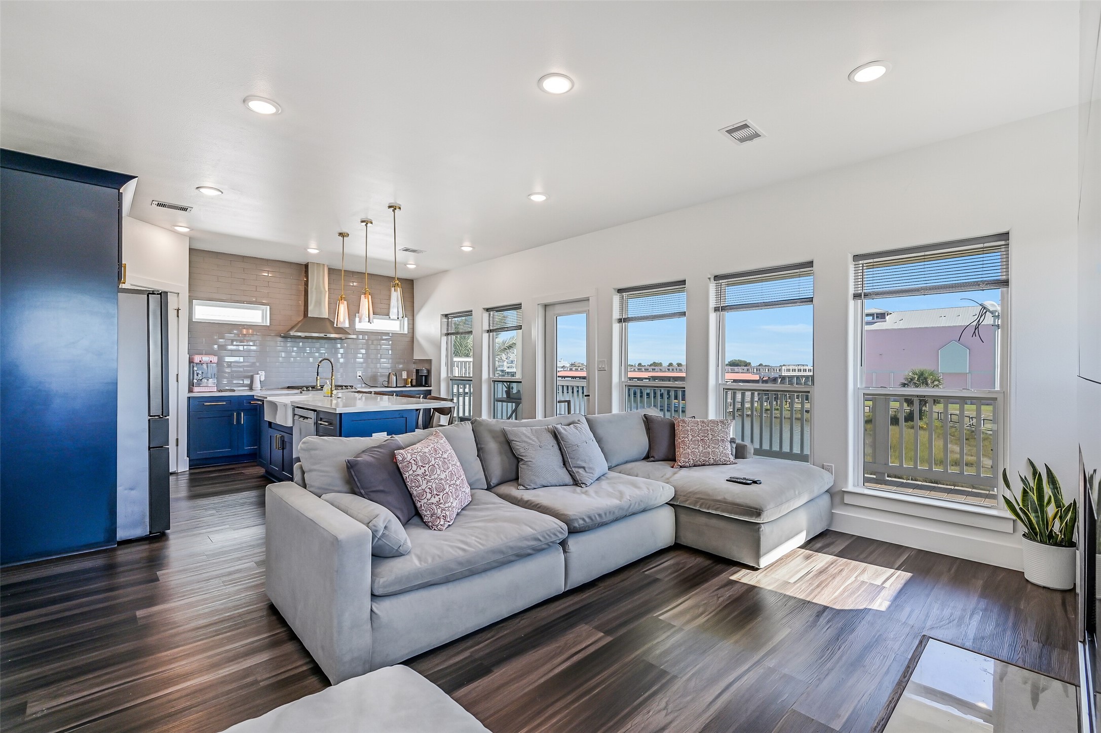 Walls of windows fill the home with natural light, while beautiful vinyl plank flooring flows throughout.