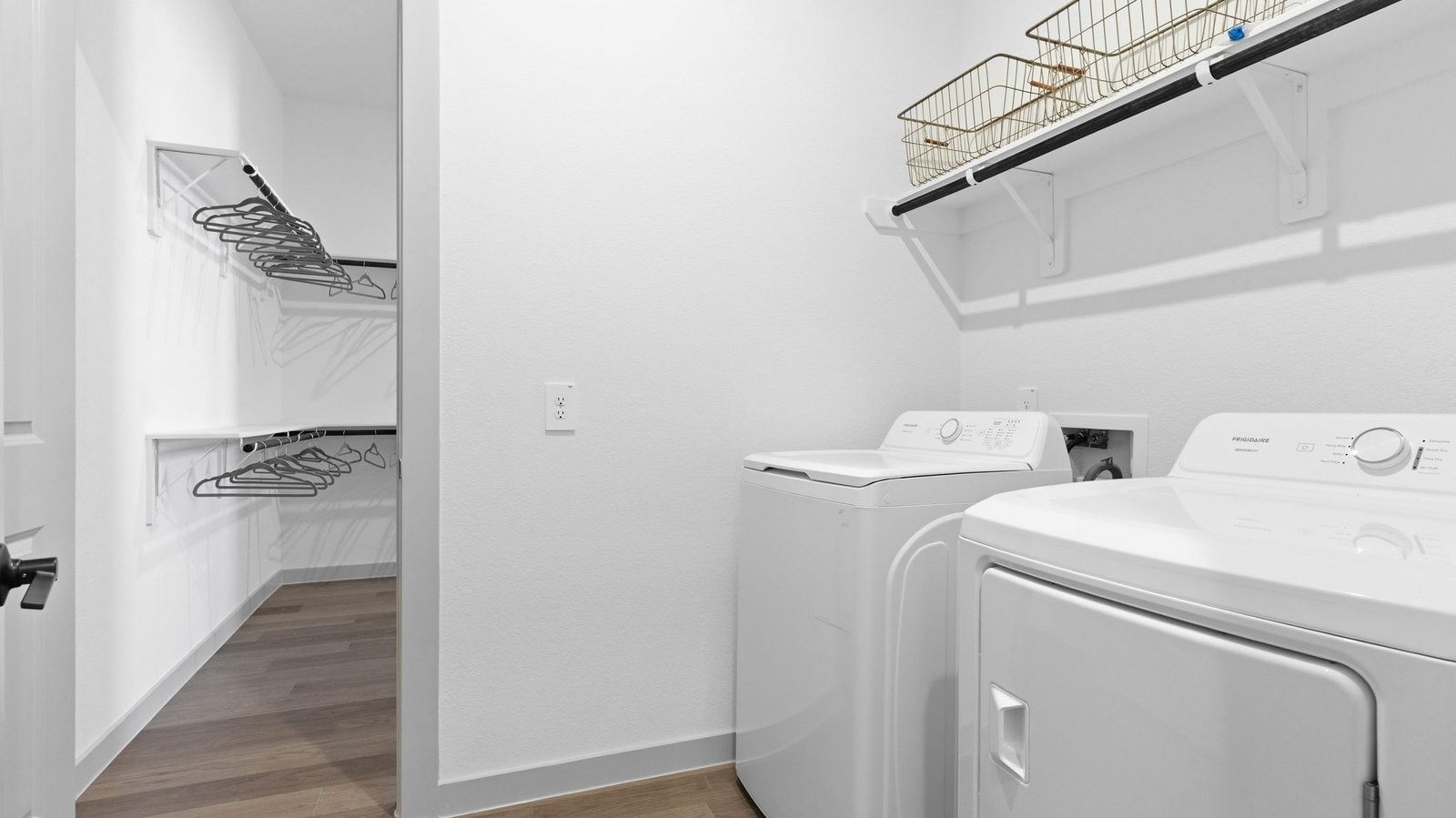 A laundry room featuring washer and dryer connections, neatly arranged with ample space for laundry tasks, and storage.