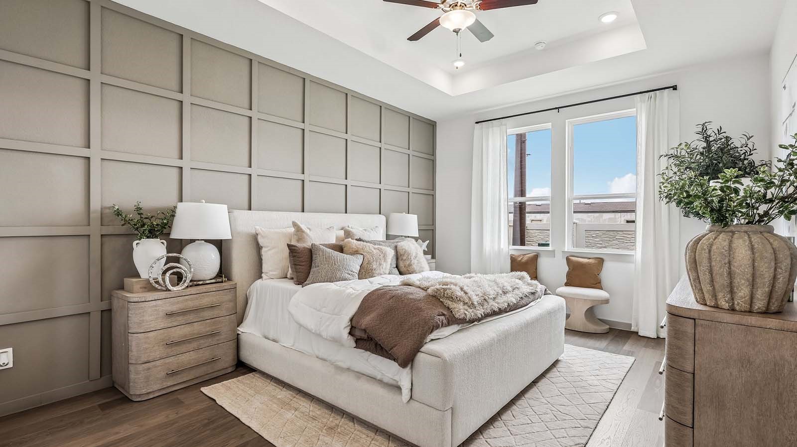 primary bedroom with an ceiling fan and large windows for natural light.