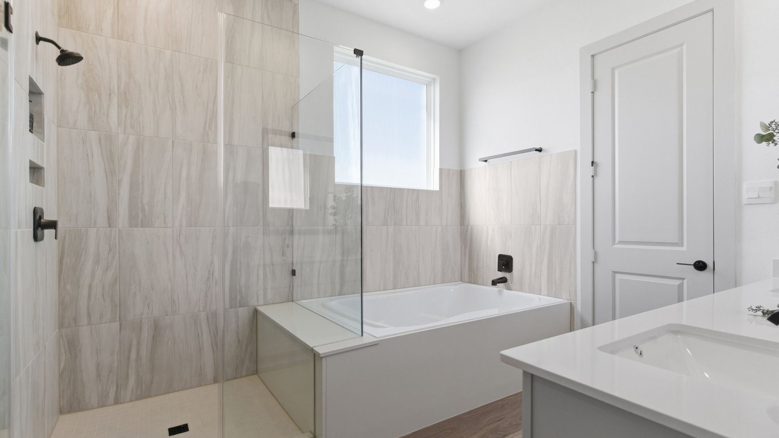 Primary bathroom with a glass-enclosed standing shower and separate soaking tub.