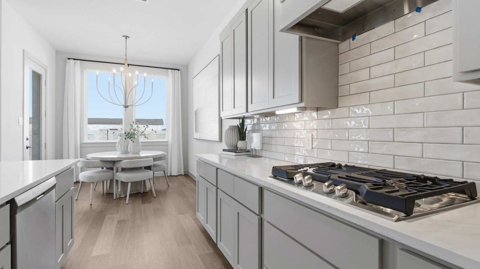 Kitchen and living area with large windows towards the back of the home with natural lighting illuminating the space