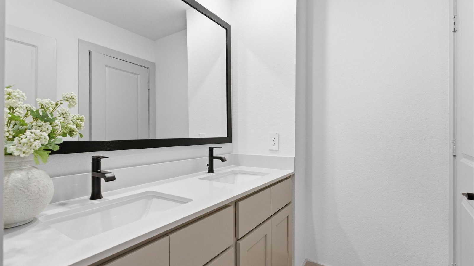 A well-designed bathroom equipped with quartz countertops, a standing tub, and a double vanity.