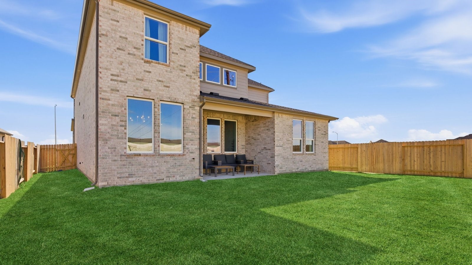 Large fenced-in backyard with a covered patio, perfect for outdoor entertaining.