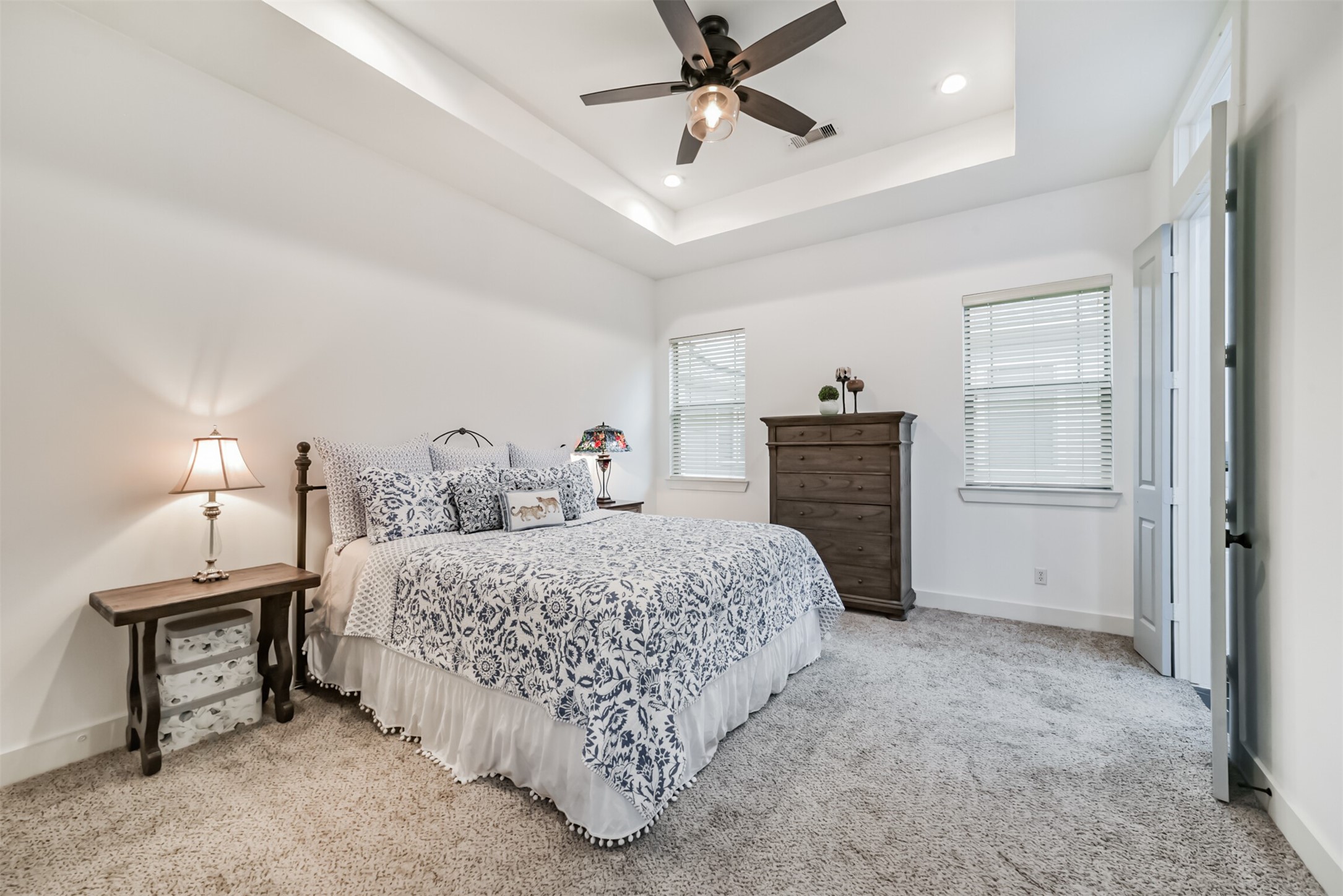 Spacious primary suite with a tray ceiling and two sunny windows, a peaceful place to unwind