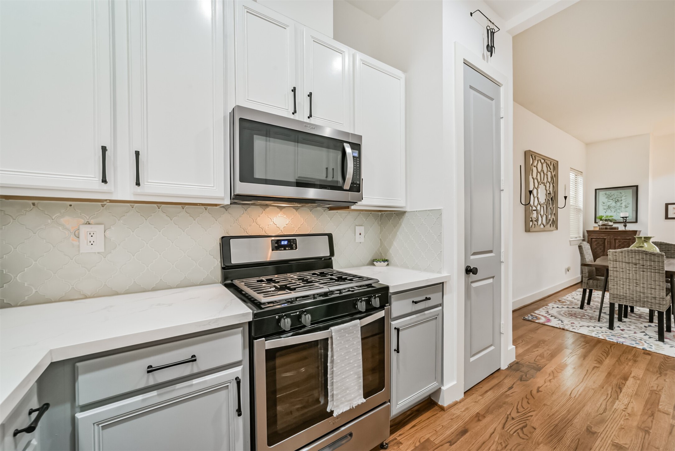 Stainless steel appliances, gas range and pantry area.