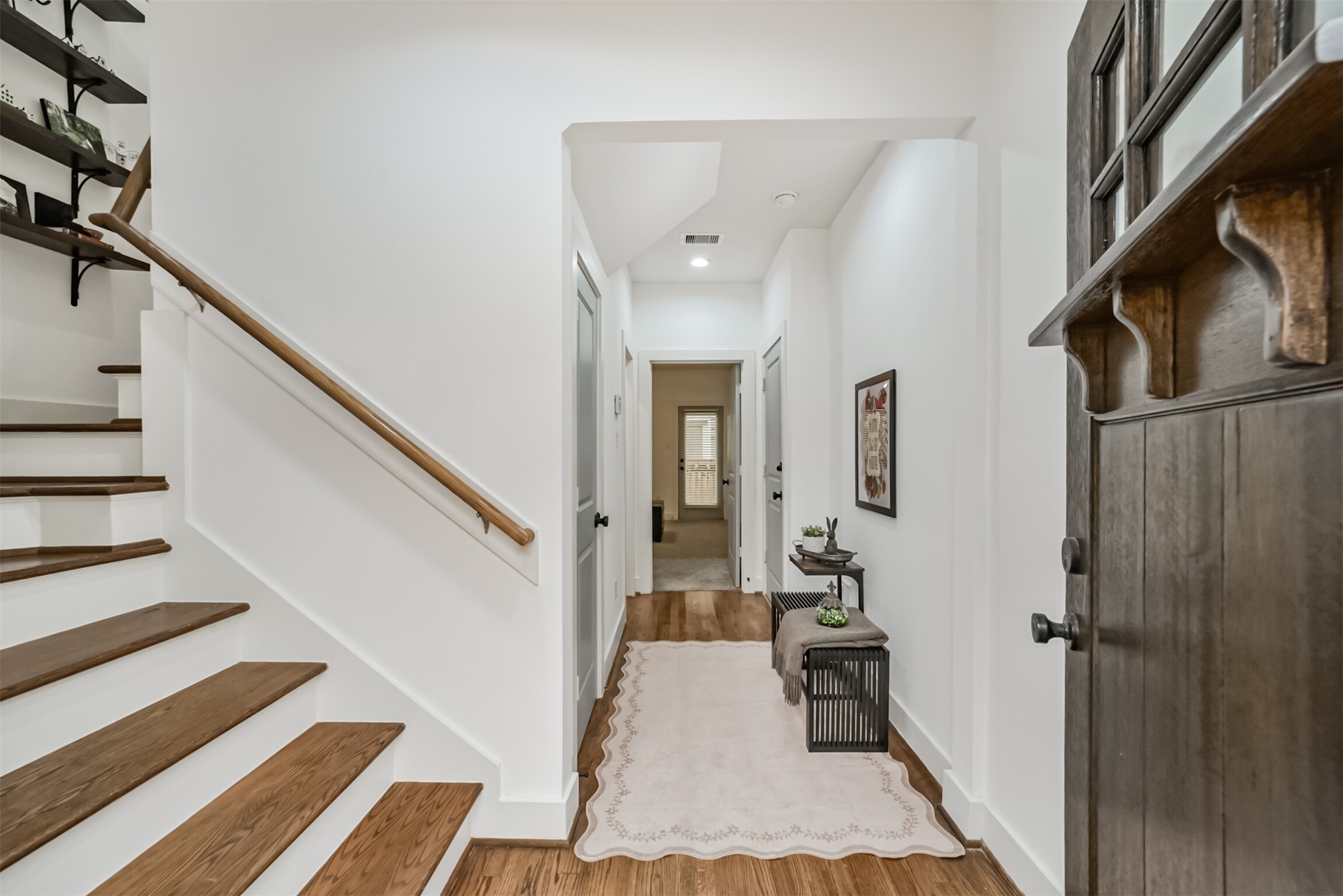 Warm, inviting entry with gleaming hardwood floors and a stylish staircase