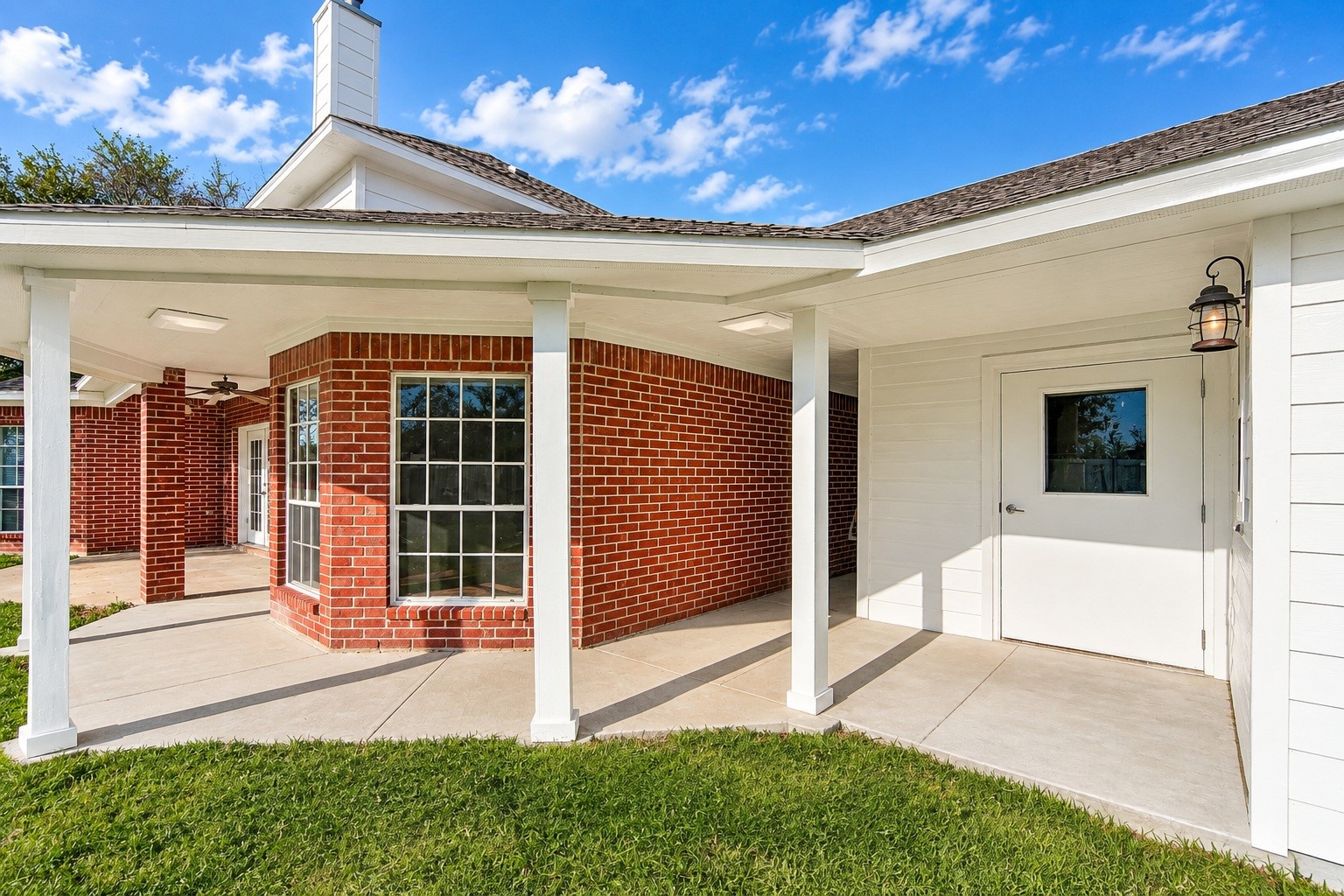 Charming home with a stylish brick exterior and a welcoming covered walkway, perfect for enjoying the outdoors.