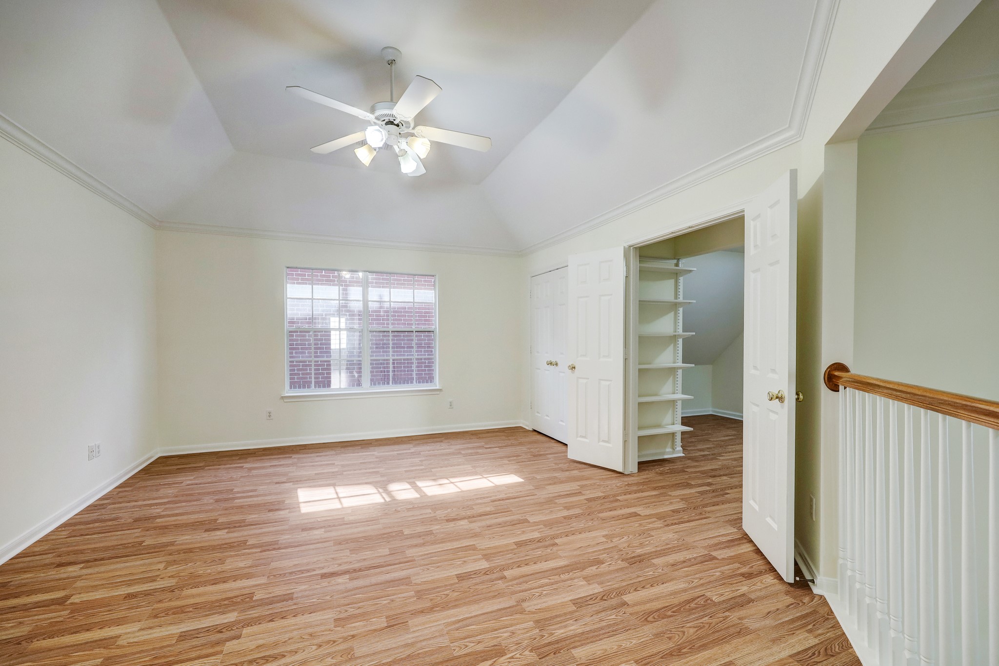 GAME ROOM: Bright and versatile space with a large window, ceiling fan, and generous built-in storage behind double doorsperfect for games, hobbies, or a secondary living area.
