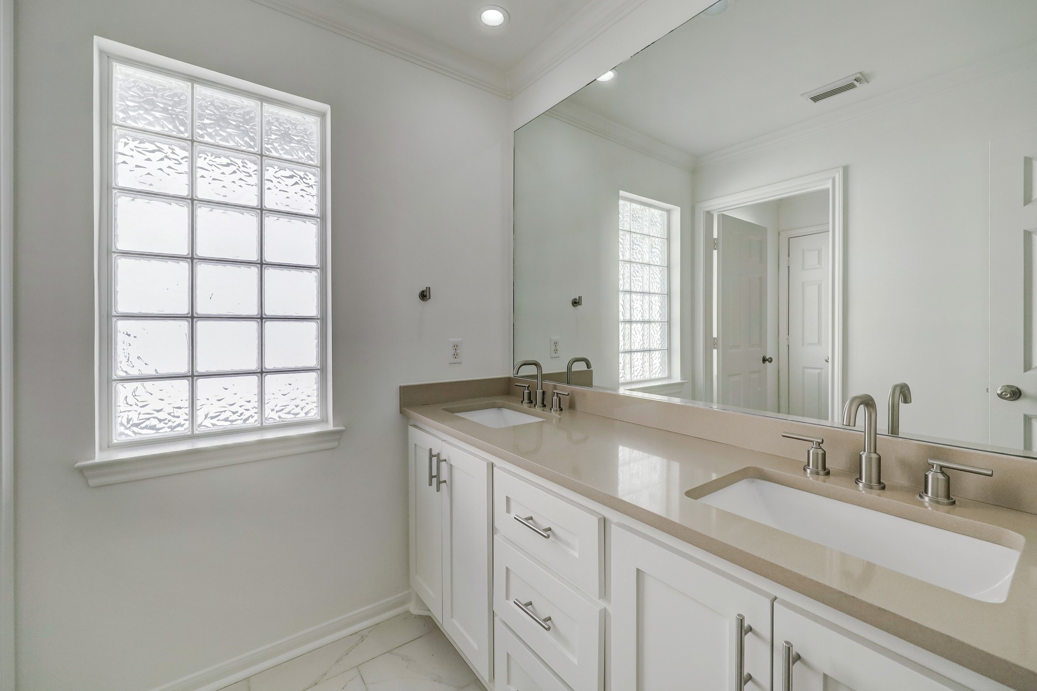 SECONDARY BATHROOM: Bright and functional with a spacious double vanity, sleek countertops, and contemporary finishesideal for shared use.