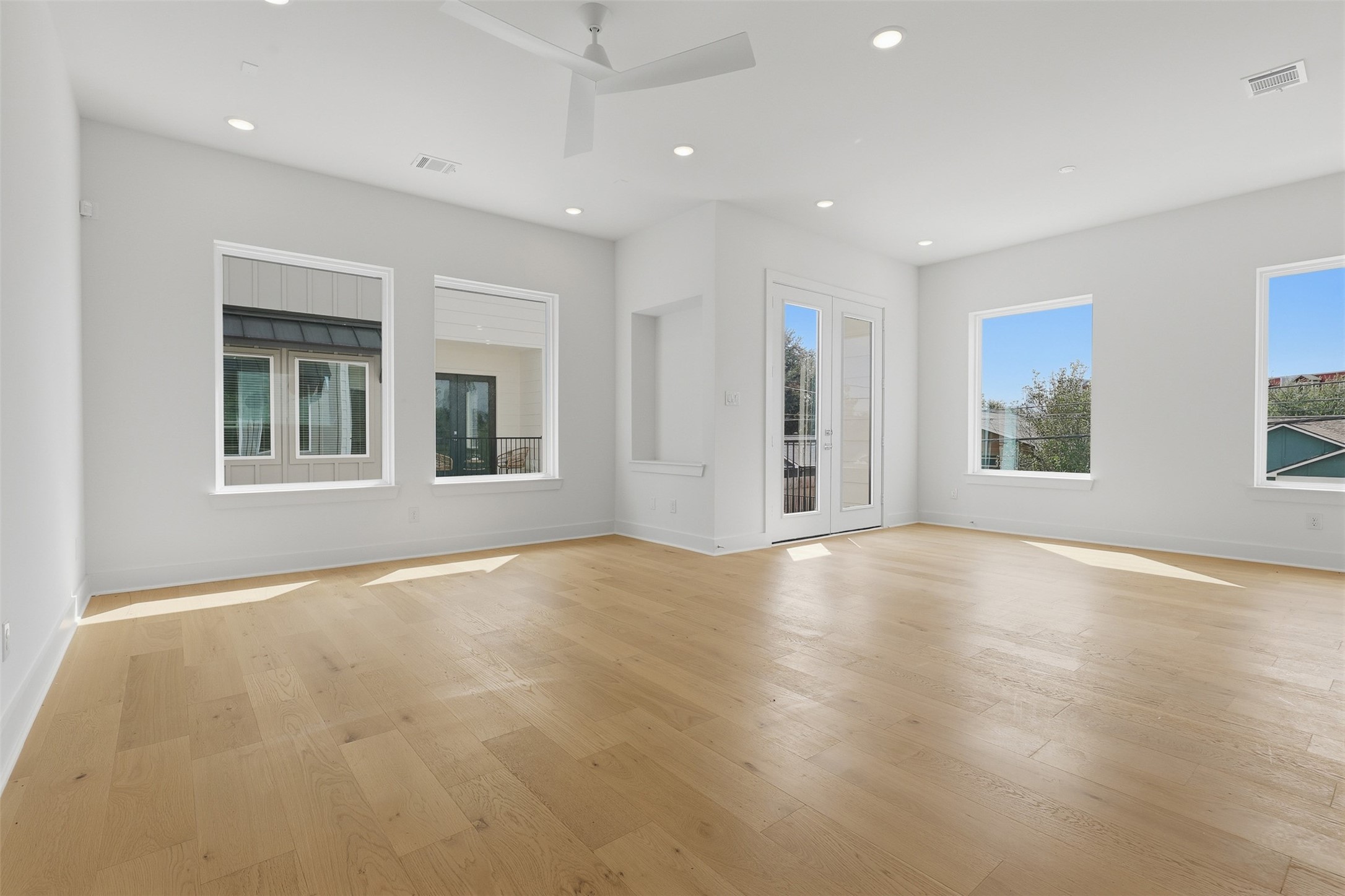 Windows wrap around the living space, with a door leading outside.