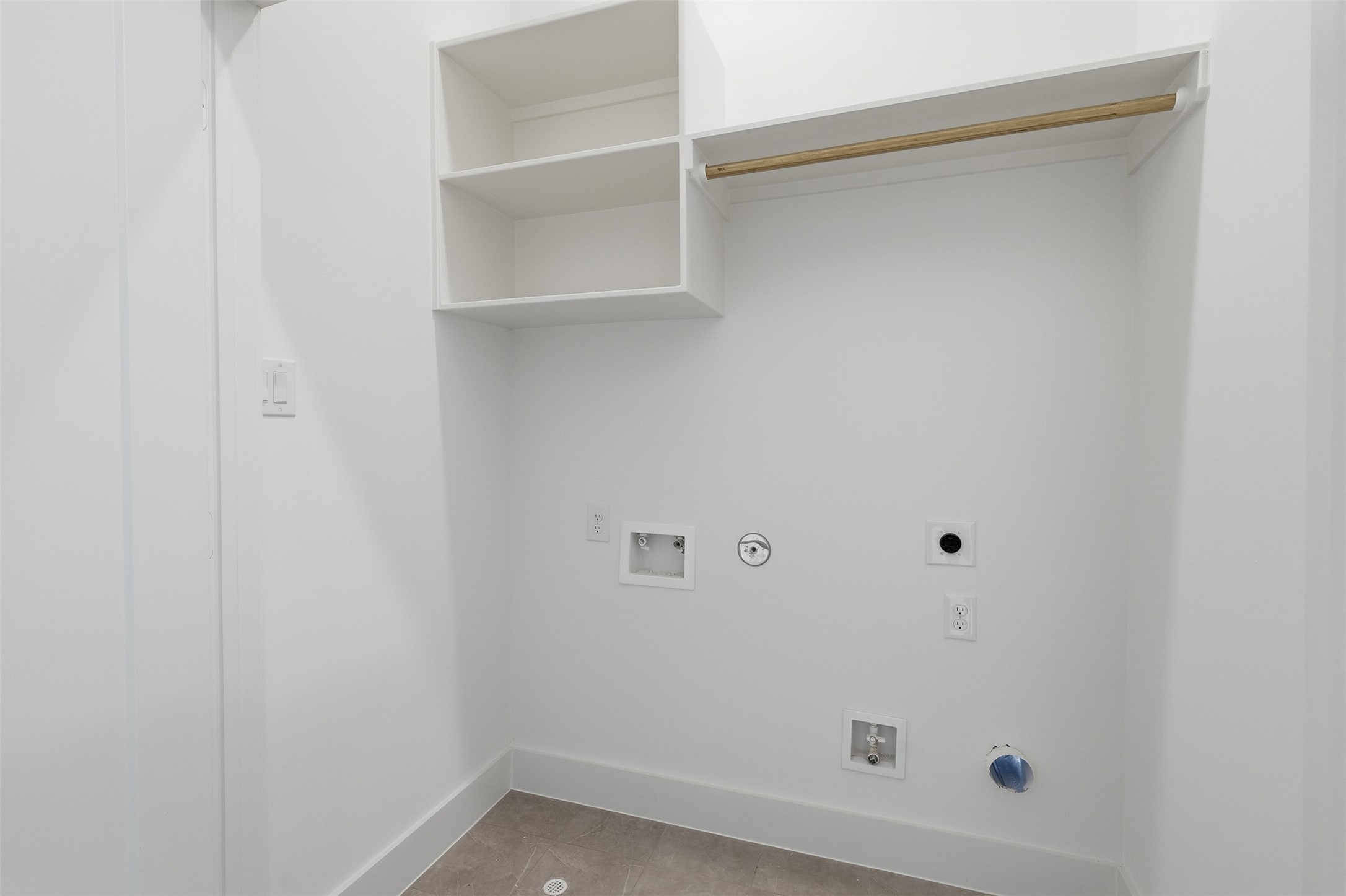 The laundry space includes appliance connections and shelving.