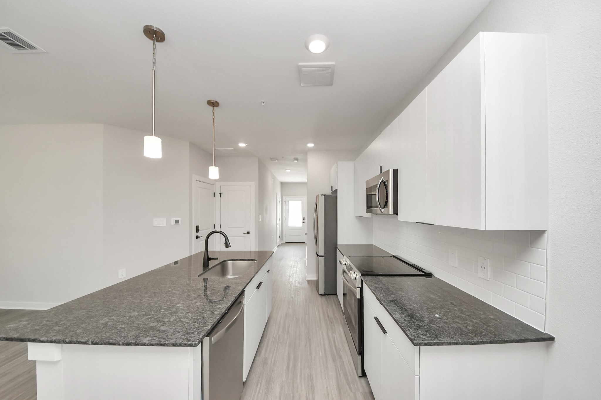 Boasting luxury finishes-stylish Island kitchen,granite counters,subway tile backsplash,ample custom cabinet space,stainless appliances,refrigerator,full size washer&dryer included,wood-like floors throughout,open concept floor plan.