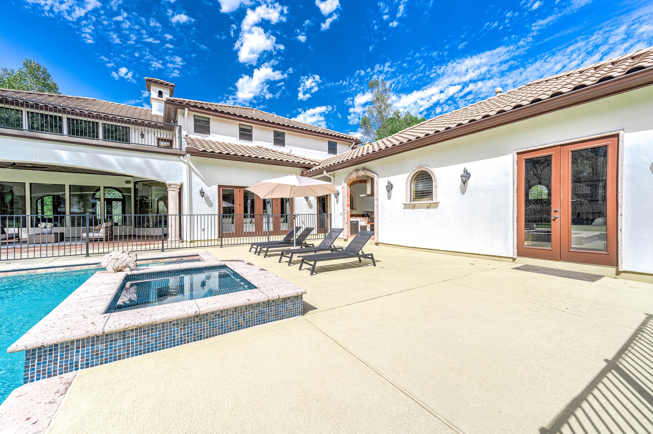 The raised spa adjoins the lap pool, with French doors connecting the guest quarters to the pool deck.