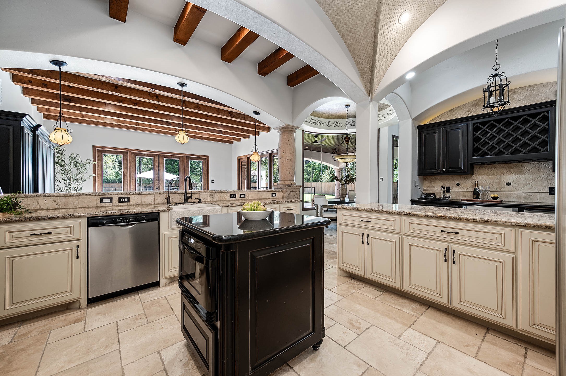 The chef's kitchen features a center island, a second sink, and abundant custom cabinetry with a built-in wine rack.