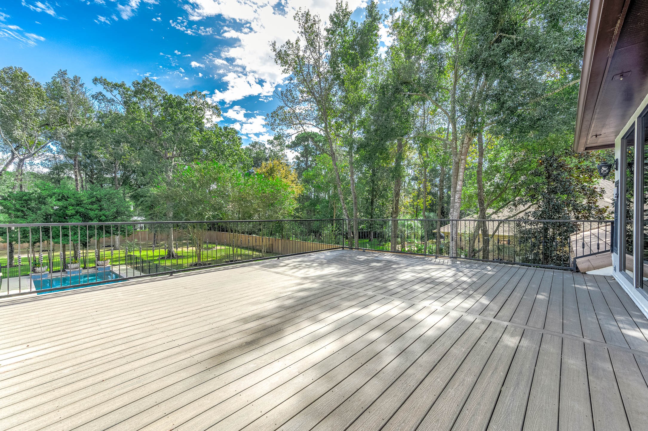 The expansive rooftop deck offers treetop views over the pool and backyard.