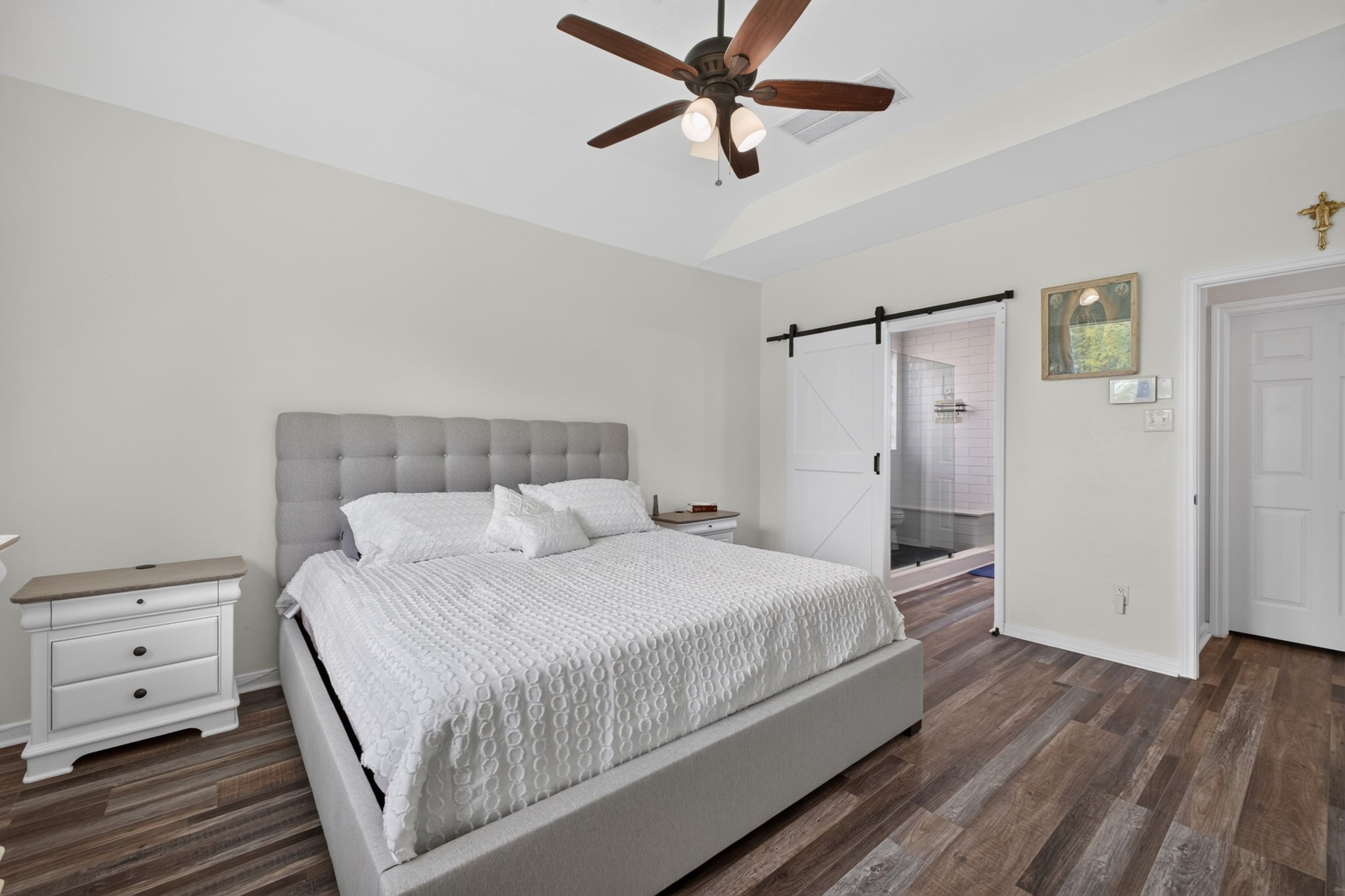 Primary bedroom with sliding barn door leading to an ensuite bathroom