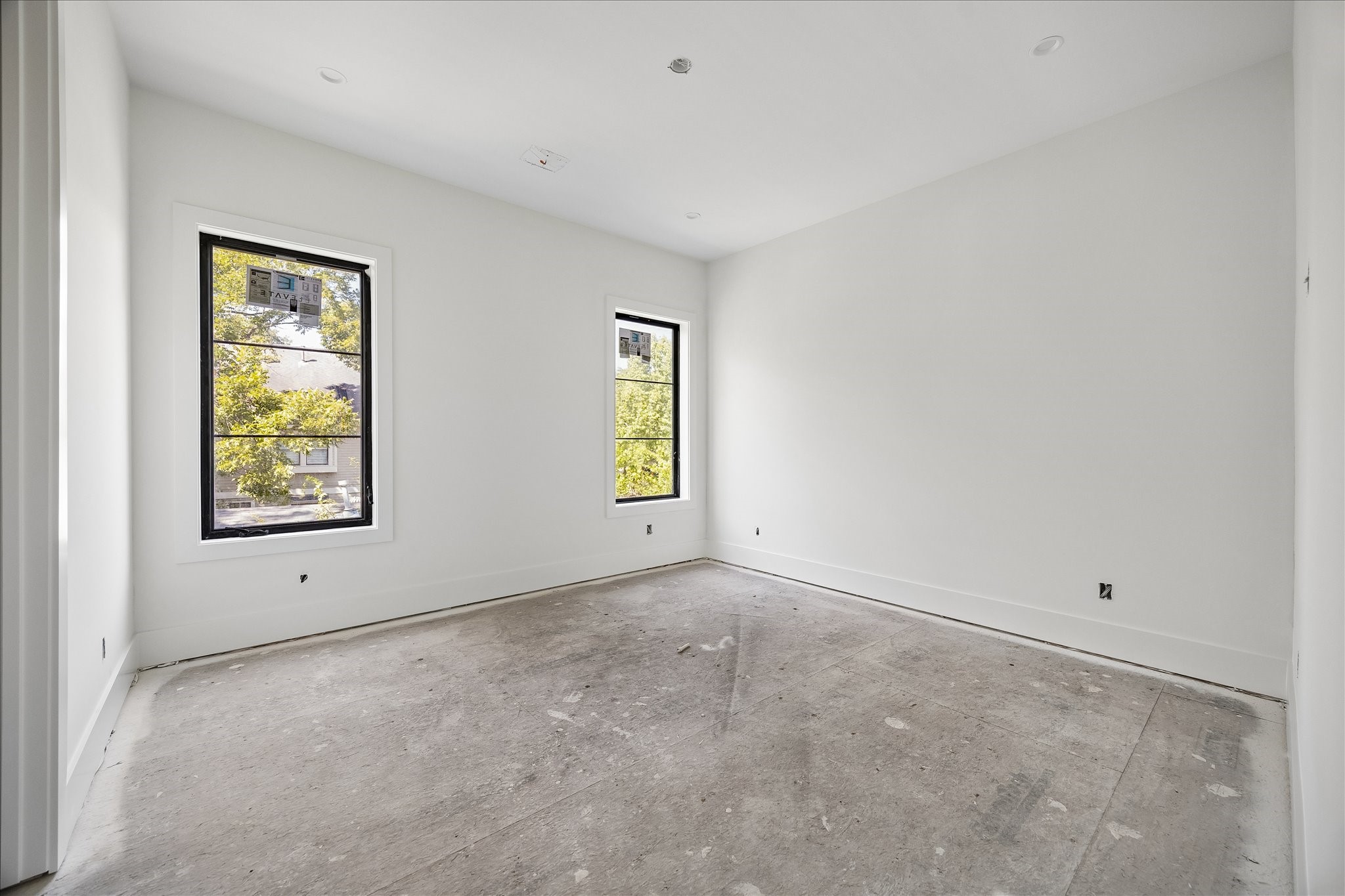 Reverse views show the spacing between the 2 windows and the broad wall areas around them. Builder specifications call for 8 inch upstairs baseboards and European oak flooring. Baseboards are visible here, while the floor remains unfinished during construction.