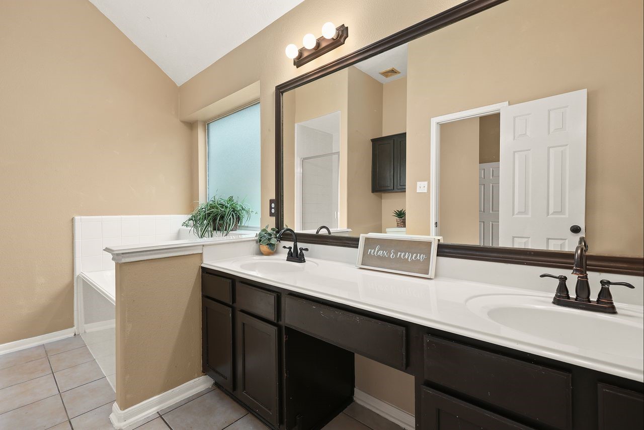 Another View of the Primary Bath Showcasing the Spacious Dual-Sink Vanity, Generous Counter Space, and Relaxing Jetted Tub.