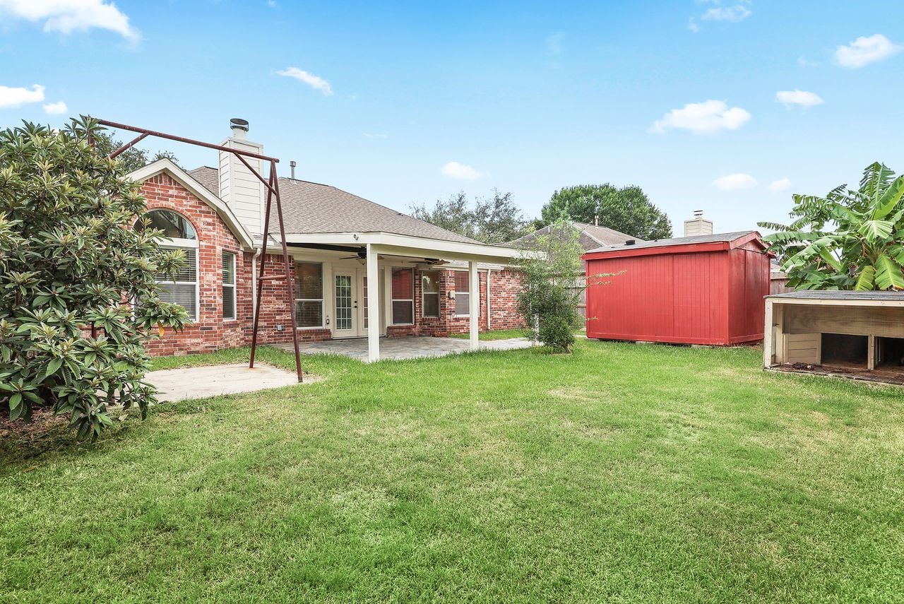 Generous Backyard Offers Plenty of Outdoor Space, an Expansive Covered Patio, and a 10x10 Storage Building for Added Convenience.