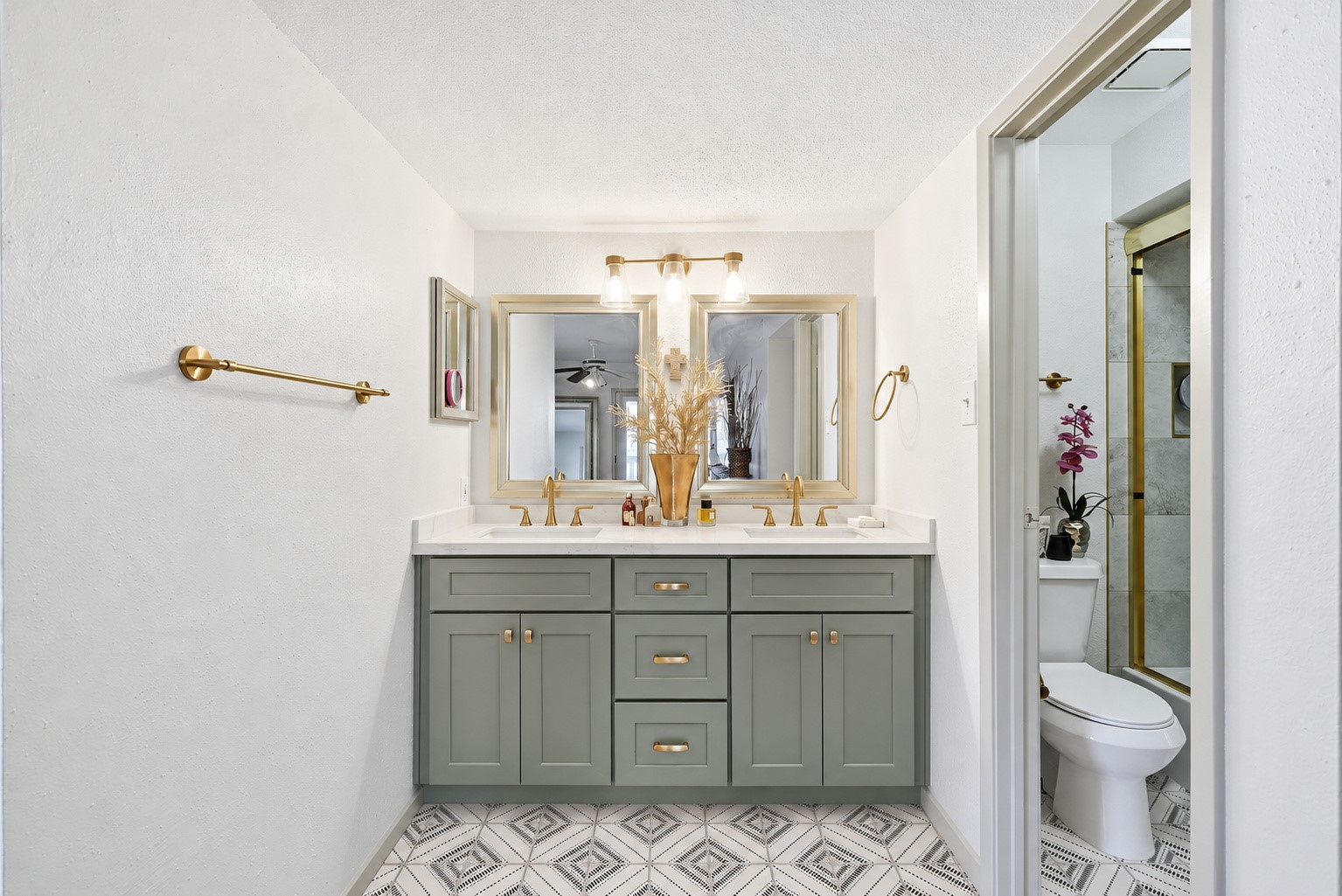 Completely remodeled primary bathroom with dual sinks, quartz countertops, and designer tile.