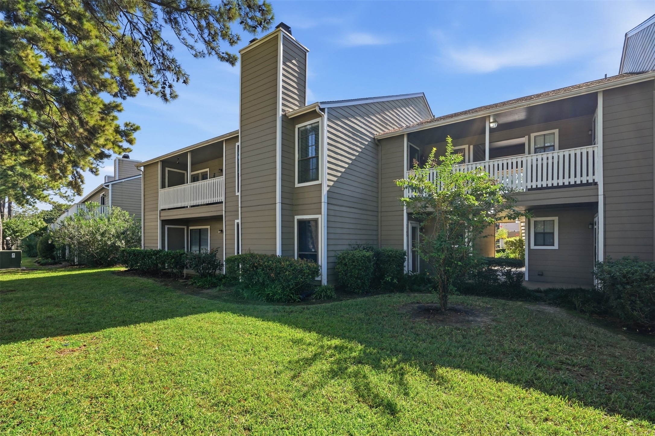Back View- Landscaped green space and mature trees throughout the condominium community.