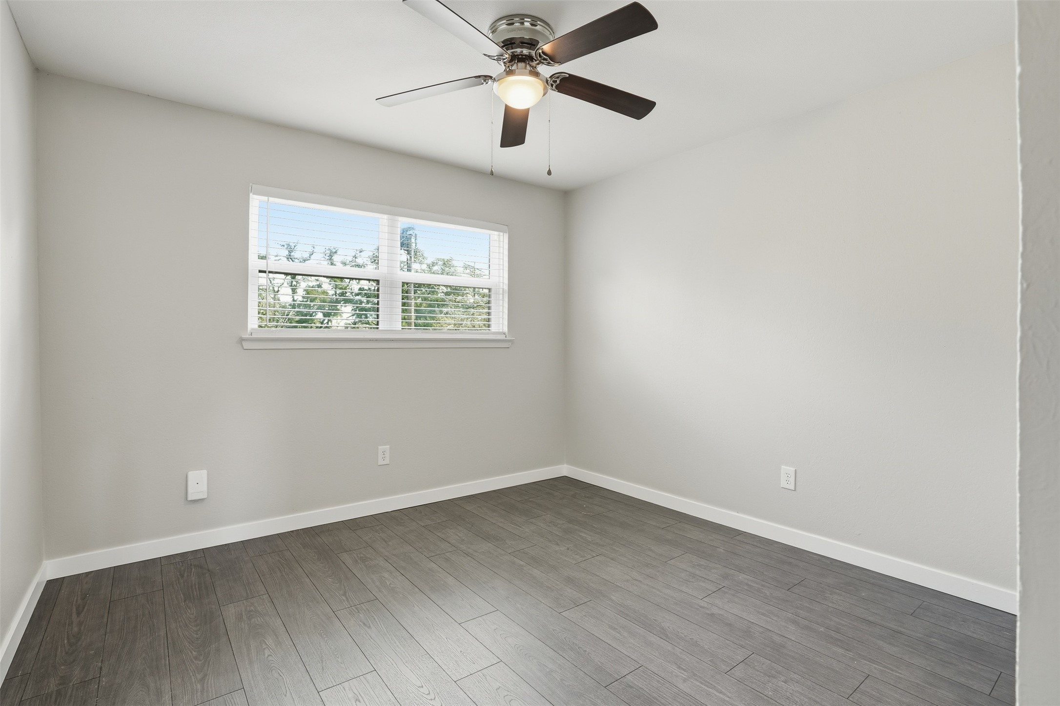 Bright secondary bedroom with natural light and a versatile layout.
