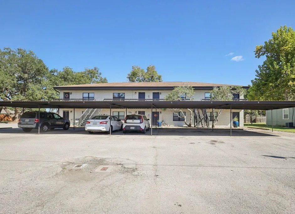 Apartment building exterior with on-site parking.