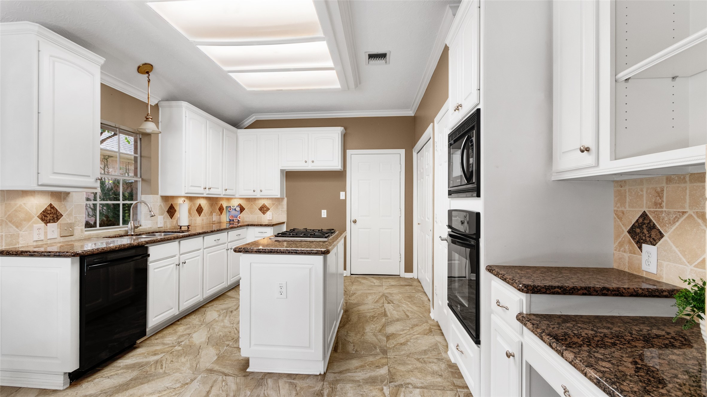 Kitchen offers granite counter tops and island with cooktop.