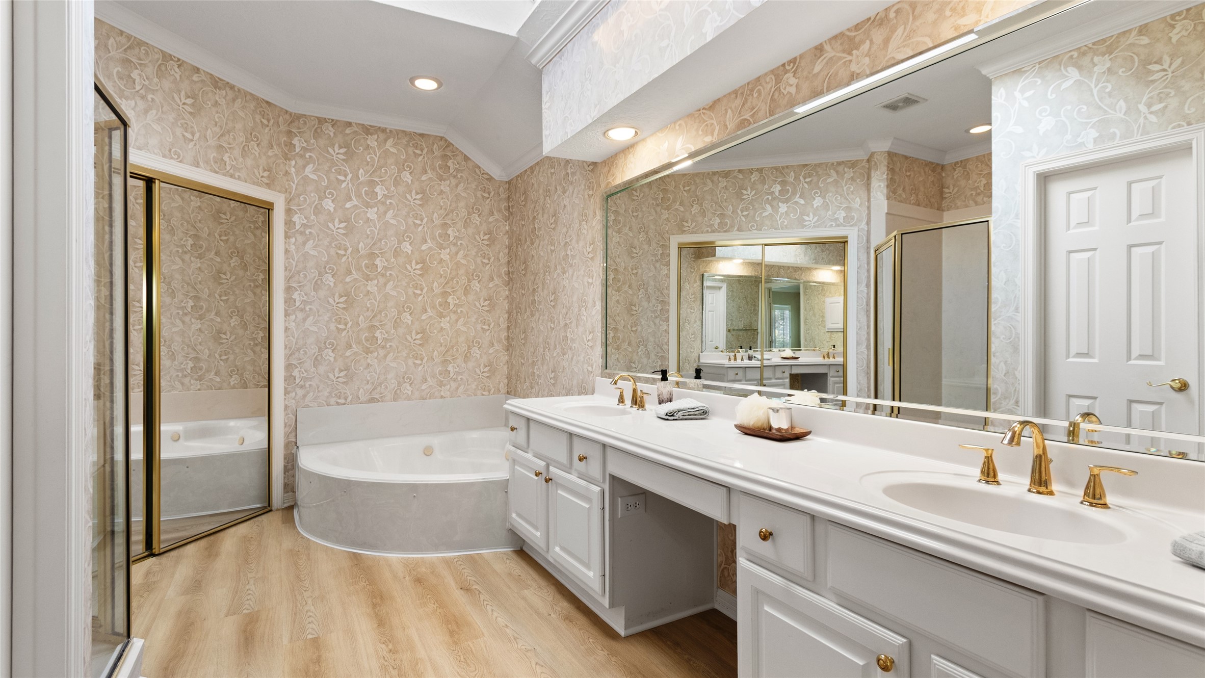 Primary bathroom offers double sinks a jetted tub and a walk in shower.